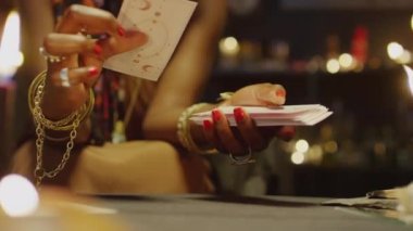 Stüdyoda mum yakarken tarot kartlarına bakarken çekilmiş görüntüler.