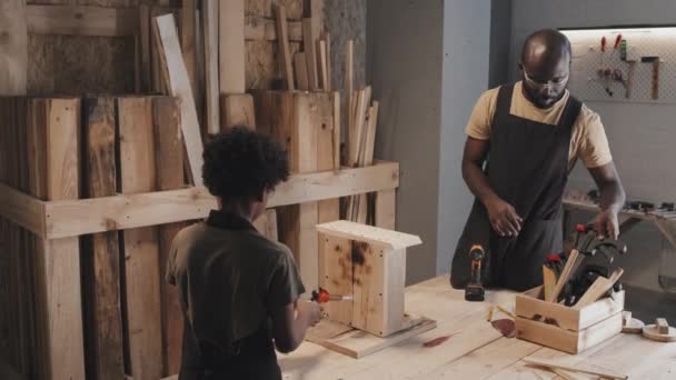 African American Boy Scorching Surface Birdhouse Table While His Father — Stock Video