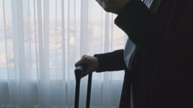 Kadın girişimcinin pencere kenarındaki lüks otel odasındaki çekimini kaldır ve çıkış yapmadan önce cep telefonu kullan.