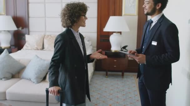 Erkek Yöneticinin Otel Odasında Elinde Dijital Tabletle Elinde Bavulla Bayan — Stok video