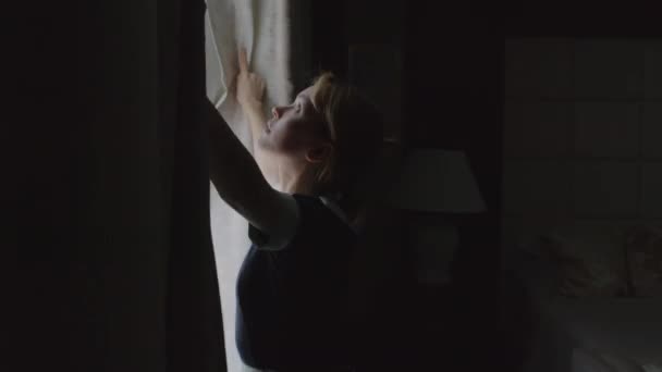 中长镜头的少女准备入住酒店房间 拉开窗帘 打开床边的灯 — 图库视频影像