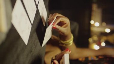 Tarot uzmanlarının ellerini dikey çekimde masaya oturturken.