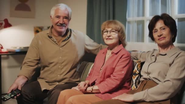 Oturma Odasındaki Rahat Koltukta Otururken Kameraya Poz Veren Neşeli Yaşlıların — Stok video