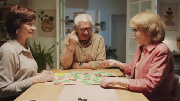 Colpo Medio Compagnia Anziani Positivi Che Giocano Gioco Tavolo Seduti — Video Stock