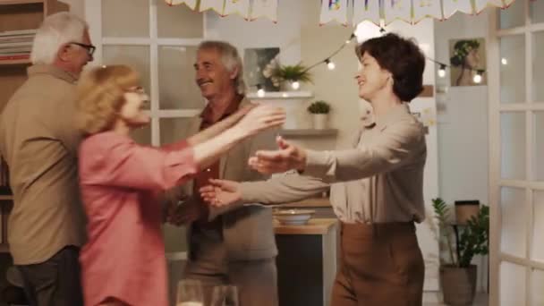 パーティーで居心地の良いフラットで誕生日のお祝いに会うとき 陽気な高齢者の友人のミディアムショット — ストック動画