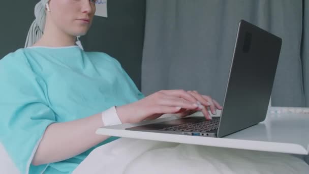 Наклоните Снимок Женщины Раком Отправляющей Сообщения Своим Друзьям Сидя Кровати — стоковое видео