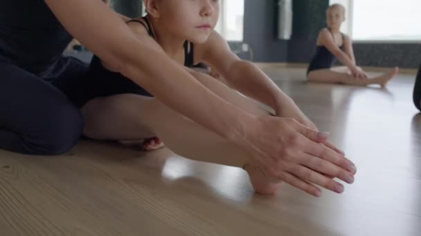 Średnie Ujęcie Małej Gimnastyczki Próbującej Wykonywać Trudne Ćwiczenia Rozciągające Nogami — Wideo stockowe