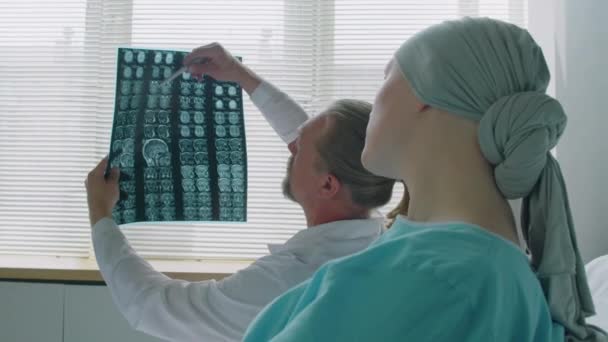 坐在医院病房里谈论脑部X光影像扫描的病人和医生的肩膀上 — 图库视频影像