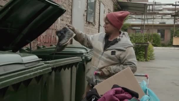 Medium Shot Homeless Man Rags Taking Shoes Trash Can Putting — Stock Video