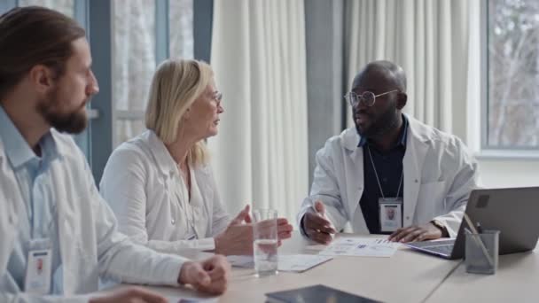 Equipo Trabajadores Hospitalarios Multiéticos Sentados Mesa Discutiendo Algunos Temas Sala — Vídeos de Stock