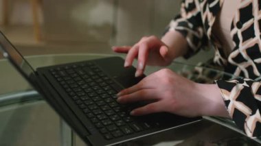 Kanserli, kel ve genç bir kadının, mutfaktayken dizüstü bilgisayarına mesaj yazışlarını yakından çek.
