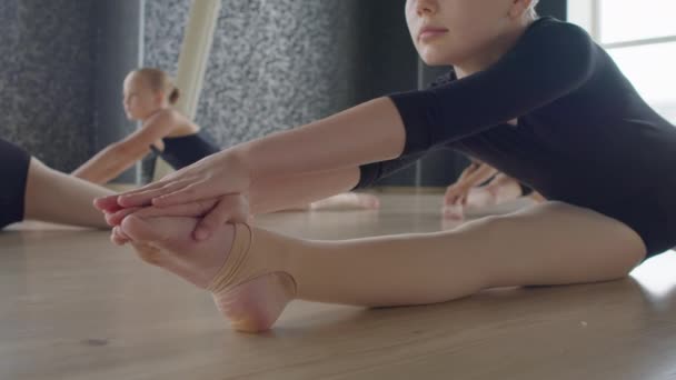 Grupo Pequeñas Bailarinas Estirando Sus Cuerpos Piernas Mientras Están Sentadas — Vídeo de stock