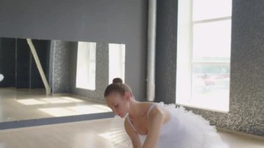 Bale dansçısının büyük pencereli stüdyoda çalışırken havada daireler çizip durduğu orta boy bir sahne.