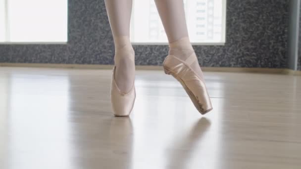 パノラマウィンドウでスタジオの床の先端の円の動きをする白いポンテントの靴の認識できない女性の足の近く — ストック動画