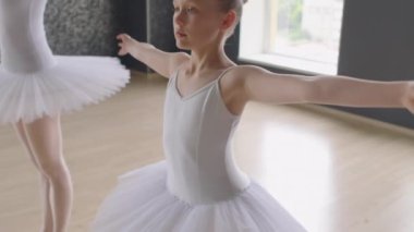 Stüdyoda bireysel dans dersi alırken balerin ve öğrencinin kollarını açtığı pozlar.