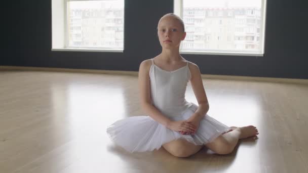 Zdjęcie Portretowe Małej Tancerki Szkoły Baletowej Siedzącej Podłodze Studia Patrzącej — Wideo stockowe