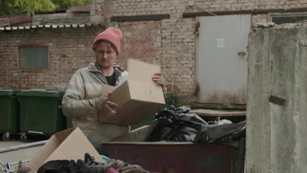 Tiro Medio Mendigo Sacando Una Caja Cartón Con Plátano Bote — Vídeos de Stock
