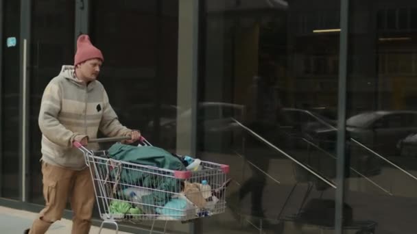 Lange Aufnahme Eines Unaufgeräumten Obdachlosen Der Mit Einkaufswagen Herumläuft Und — Stockvideo