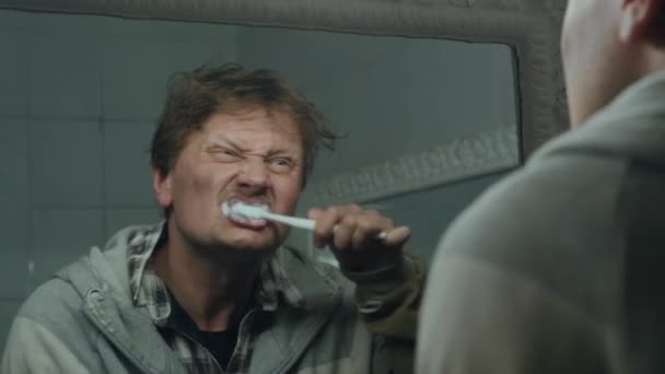 Tuvalette Aynanın Önünde Diş Fırçasıyla Dişlerini Temizleyen Genç Evsiz Adamın — Stok video