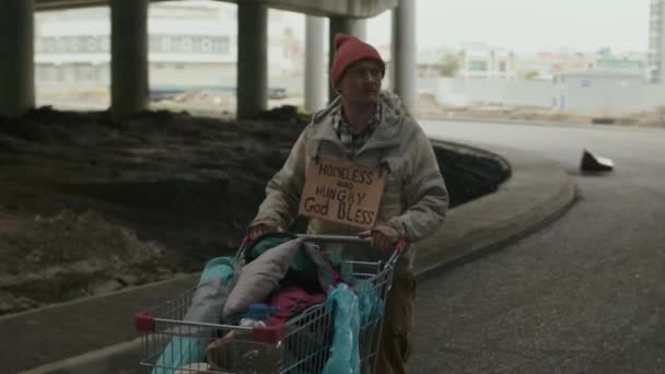 Средний Выстрел Бездомный Человек Лохмотьях Оглядываясь Вокруг Выбирая Направление Собирается — стоковое видео