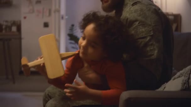 Askeri Üniformalı Beyaz Bir Baba Evdeki Kanepede Otururken Tahta Uçakla — Stok video