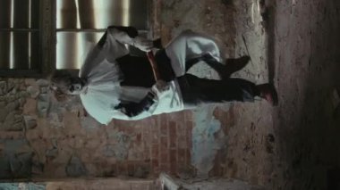 Korkunç bir yerde terk edilmiş bir odada çılgın palyaço dansı yaparken dikey çekim.