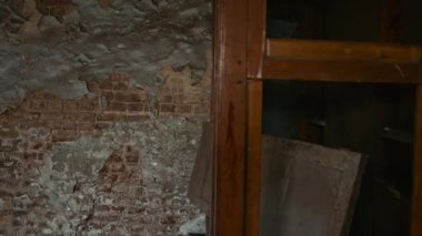 Geniş açıda, köşeden bakan tüyler ürpertici palyaço ve eski püskü duvarları olan odada kameraya bakan izleyiciye bakıyor.