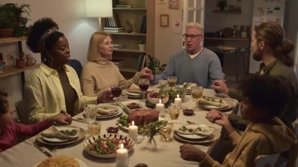 Familia Multiétnica Tomándose Las Manos Rezando Mientras Están Sentados Mesa — Vídeo de stock