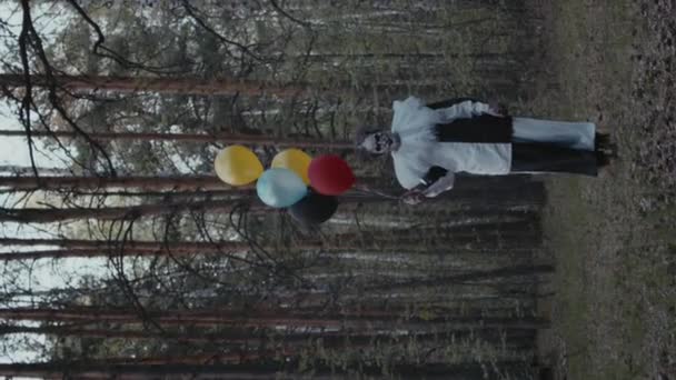 어두운 숲에서 다채로운 풍선을 광대의 카메라를 — 비디오