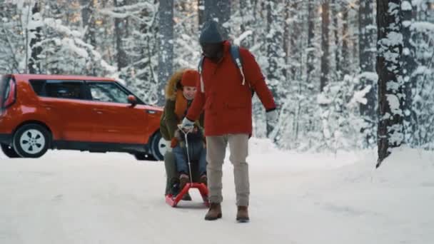 Długie Ujęcie Wieloetnicznych Rodziców Jeżdżących Sankach Śnieżnej Zimie Czerwonym Samochodem — Wideo stockowe
