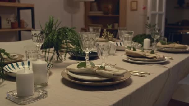 Versierde Feesttafel Met Wit Tafelkleed Borden Wijnglazen Kaarsen Dennentakken Erop — Stockvideo