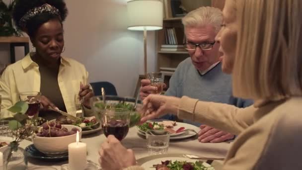 축하하는 테이블에 앉아있는 구성원의 접시에 샐러드를 코카서스 여성의 — 비디오