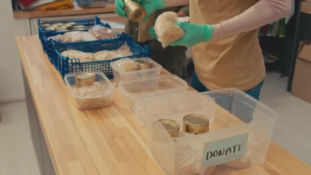 协助人员在捐赠中心工作时 将罐头食品和面条放入装有补给品的盒子中 将照片倾斜 — 图库视频影像