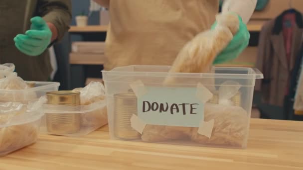 慈善项目协调员在储藏室工作时在捐赠箱中添加食物供应的剪影 — 图库视频影像