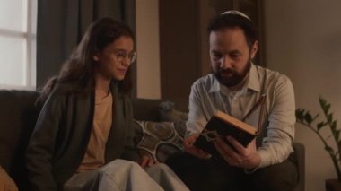 Orta yaşlı Yahudi bir adam ve genç bir torunun evdeki kanepede birlikte otururken, elinde kutsal Tevrat kitabı tutan, kızlarla konuşan, soru soran ve mesajlardan pasajlar okuyan bir adam.