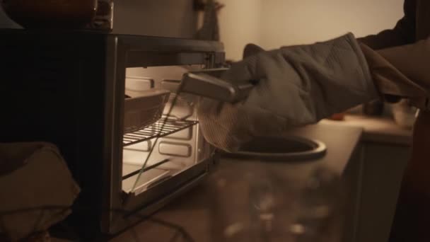在家里准备光明节晚餐时 身着手套打开烤箱门 拿着热腾腾的烤盘的无法辨认的犹太妇女的手的特写镜头 — 图库视频影像