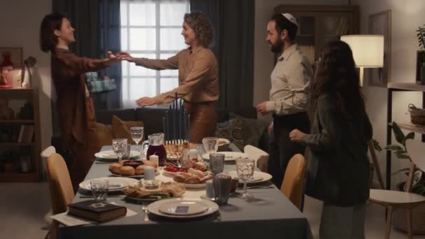 하누카 식사를위한 테이블을 유대인 부모와 그들에게 선물을주고 포옹하고 행복한 휴가를 — 비디오
