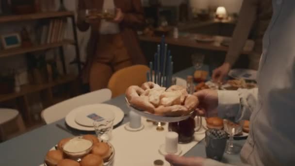 가족과 Hanukkah 휴가를 준비를하면서 식탁에 음식과 접시를 유대인 친구의 클로즈업 — 비디오