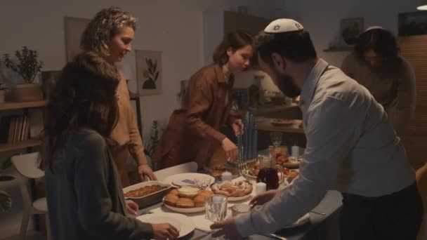 다섯의 유대인 가족의 키파를 집에서 하누카 식사를 식탁에 식기와 음식을 — 비디오