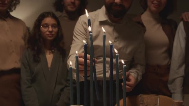 中年ユダヤ人男性のキッパスカルキャップで シャムシュを使って8本のハヌカのろうそくを点灯し その後 それを真ん中に置き 喜びで踊る — ストック動画