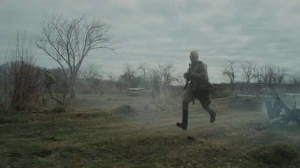 二战重演时身着苏联红军制服的男子手持武器在战场上奔跑的追踪镜头 — 图库视频影像
