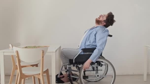 精神障害の若い男性患者は 口を開いて天井を見上げる共通の部屋で車椅子に座っています — ストック動画