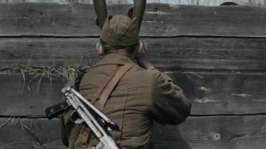 Genç Kızıl Ordu askeri düşman birliğini tespit etmek için siper dürbünü kullanıyor. Sonra da asker arkadaşlarına emir veriyor.