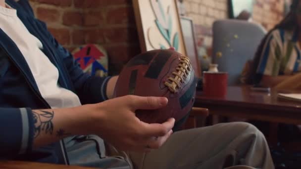 Joven Irreconocible Sentado Habitación Del Loft Girando Fútbol Mientras Conversa — Vídeos de Stock