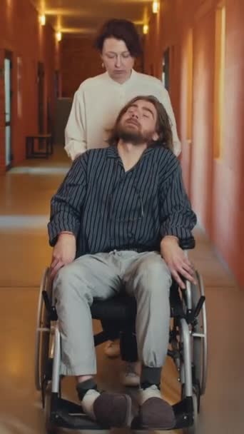 Vertikální Záběr Profesionálního Zdravotnického Pracovníka Kráčejícího Chodbě Tlačení Invalidního Vozíku — Stock video