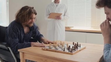 Zihinsel sorunları olan iki genç adam satranç oynuyor. Profesyonel psikiyatrist ortak odada onlara bakarken notlar alıyor.
