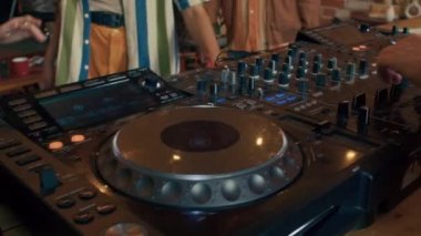 Partide 90 'ların estetiğini kullanarak müziği karıştıran tanınamayan genç erkek DJ' in orta boy yakın çekimi.