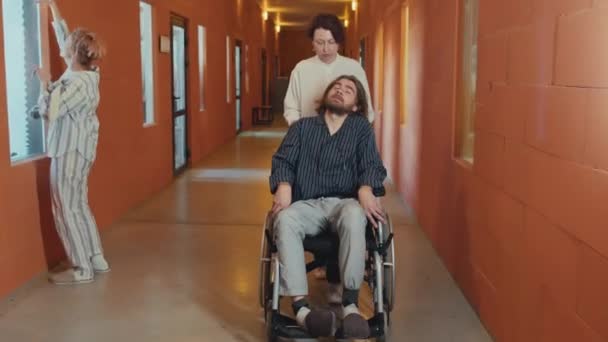 Kvinnlig Psykiatri Specialist Promenader Längs Korridoren Driver Rullstol Man Patient — Stockvideo