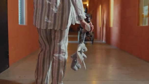 有精神分裂症的成年女性抱着玩具兔沿着避难走廊行走的选择性聚焦拍摄 — 图库视频影像