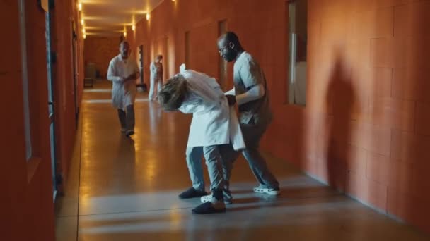 Zwei Der Anstalt Tätige Ärzte Halten Den Aggressiven Patienten Zwangsjacke — Stockvideo